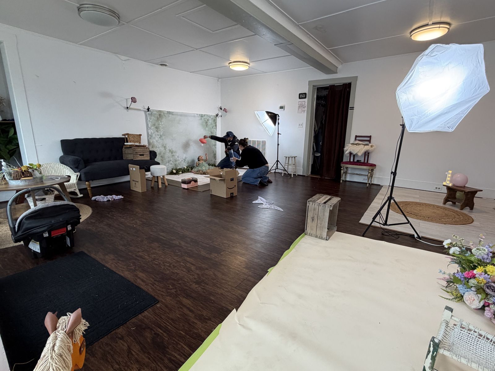 A floral backdrop set with props, a couch, and studio lighting