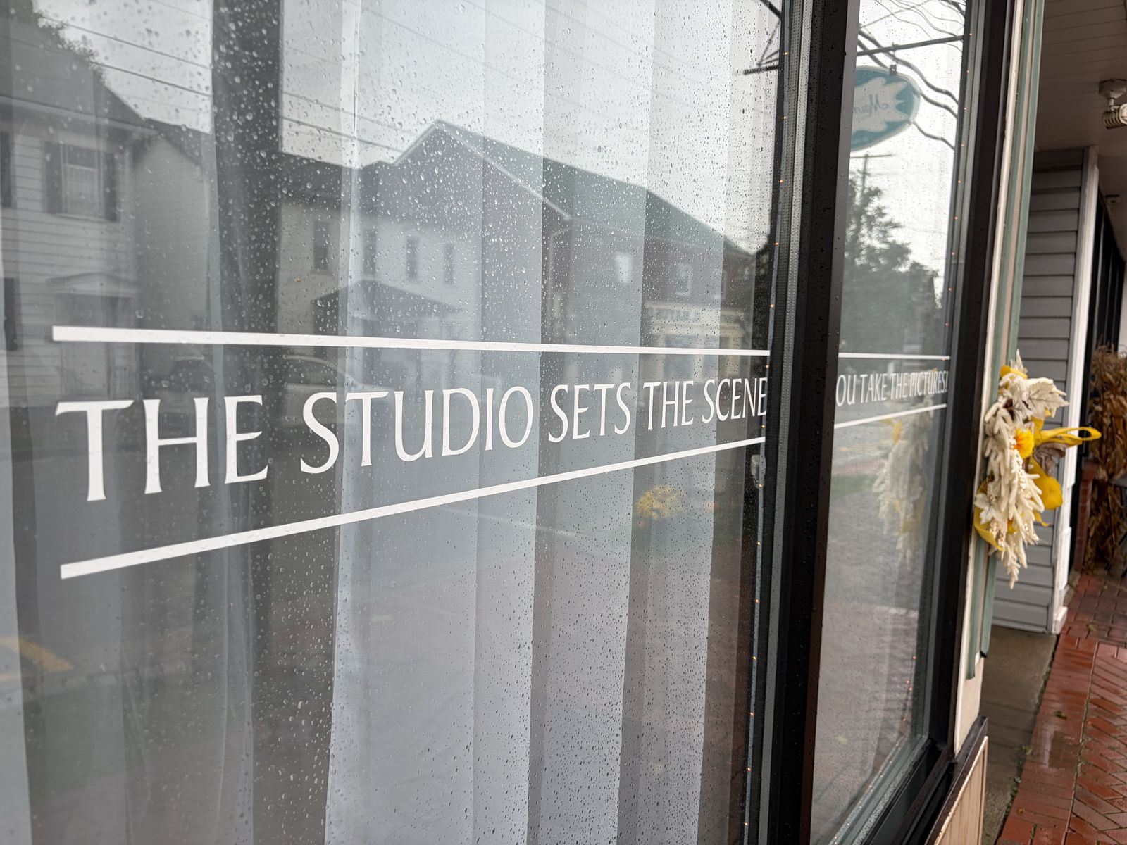 Window lettering reading The Studio Sets The Scene